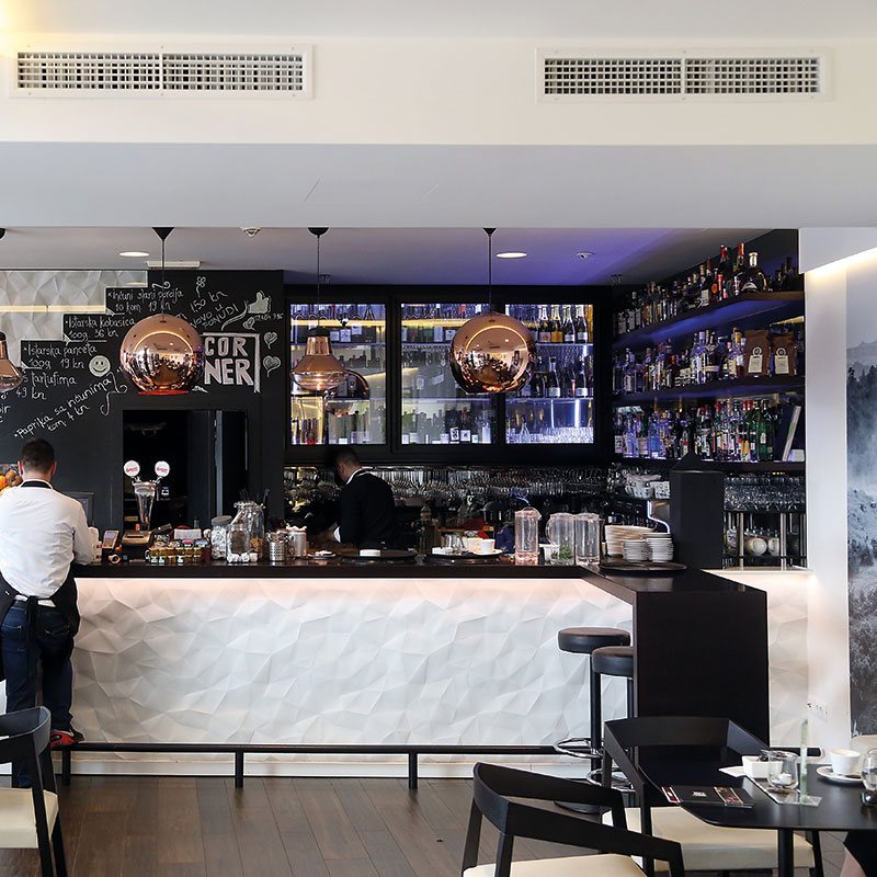 Ceiling grilles above the bar and seating in a cafe bar