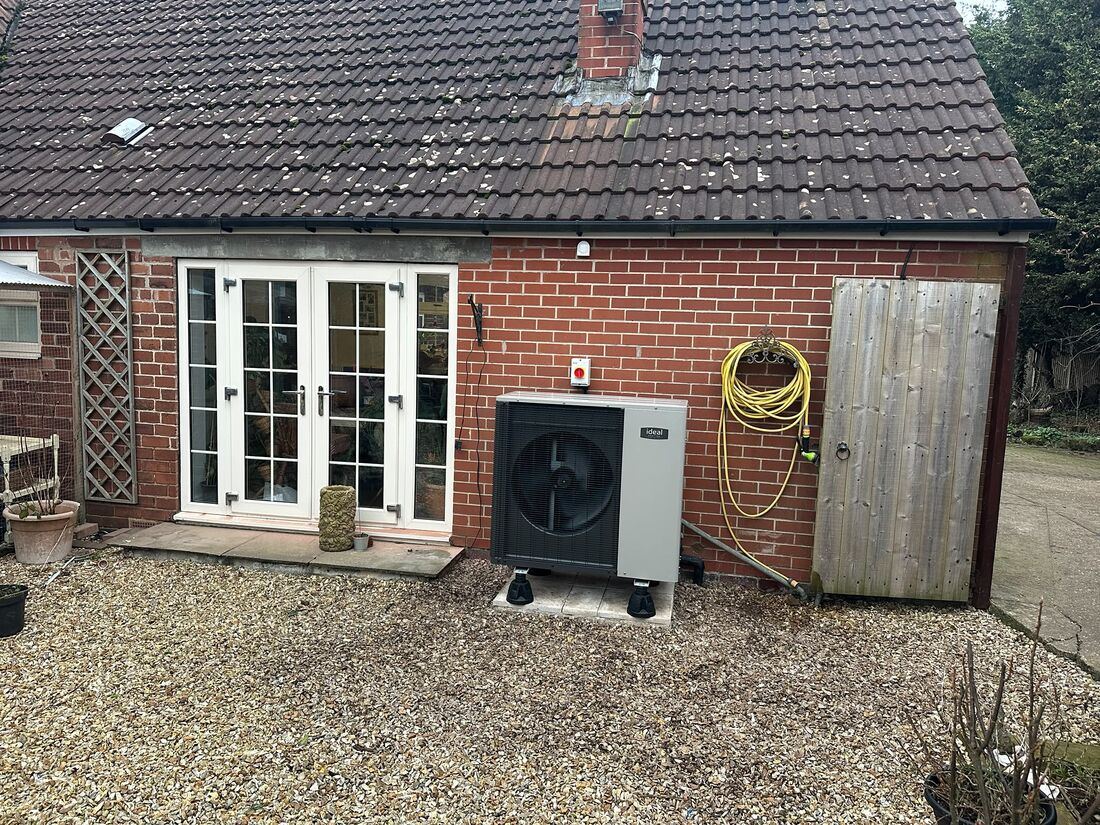 Air source heat pump mounted on a level base beside a house in Worksop